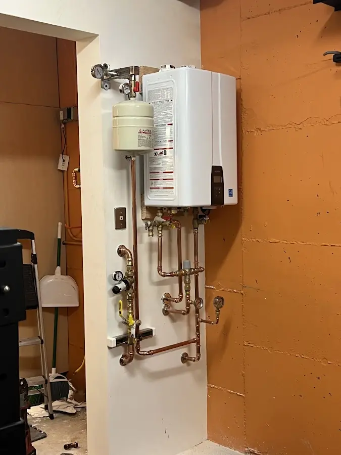 Plumbing technician inspecting water heater connections in Chatham